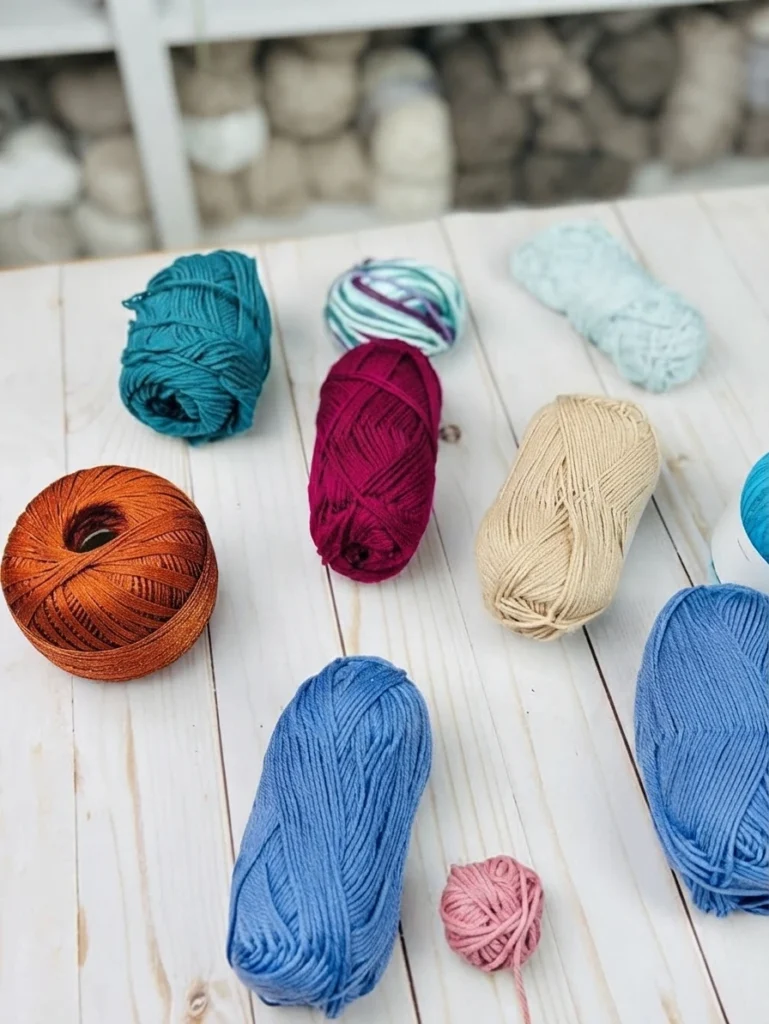 Colorful skeins of summer crochet yarn arranged on a white wooden surface