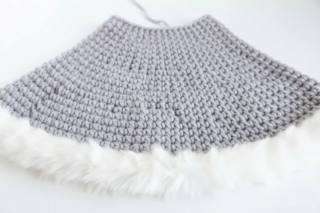 Jupe de sapin crochetée gris clair, étalée avec une bordure blanche en fausse fourrure.